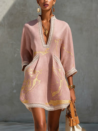 Vestido corto estampado en oro rosa con escote en V y encaje de crochet.